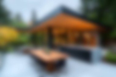 Zarif mimarisi olan, sıcak ışıklandırmalı, sakin bir bahçe ortamında rahatlamak ve toplanmak için mükemmel, çarpıcı bir modern açık hava yaşam alanı..