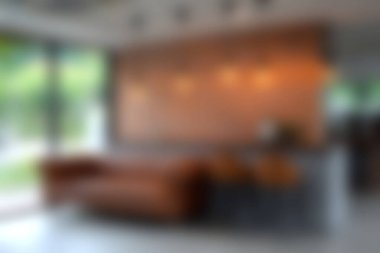 Kahverengi bir kanepe ve zarif ahşap bir duvar dekorunun bulunduğu rahat, çağdaş bir oturma odası. Doğal ışık şık atmosferi güçlendirir, rahatlamak için davet edici bir alan yaratır..