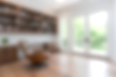 Bu resim, doğal ışık, ahşap mobilyalar ve rahatlama için ideal davetkar bir atmosfer içeren parlak ve modern bir oturma odasını gösteriyor..