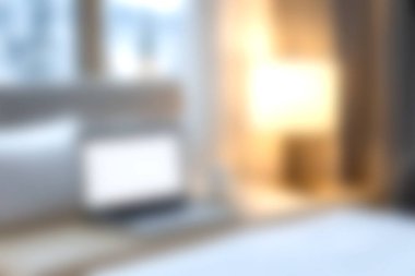 Rahat bir yatak odası sahnesi, yumuşak ışıklandırma ve yatağın üzerinde dizüstü bilgisayar, uzaktan çalışma ya da rahatlama için ideal. Atmosfer huzur ve sükunet verir..