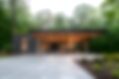 Büyüleyici bir modern ev tasarımı, yemyeşil ve uzun ağaçların arasında eşsiz bir mimari stil sergiliyor. Doğa ve mimarlık meraklıları için ideal..