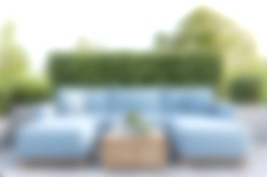 Bereketli yeşilliklerle çevrili, rahatlama ve toplanma için ideal rahat mavi bir kanepenin olduğu sakin bir açık hava yaşam alanının tadını çıkarın..