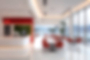 Parlak ve modern bir ofis içinde canlı kırmızı aksanlar ve bol miktarda doğal ışık sergileniyor. Geniş planda minimalist mobilyalar ve profesyonel bir atmosfer için zarif bir dekor yer alıyor..