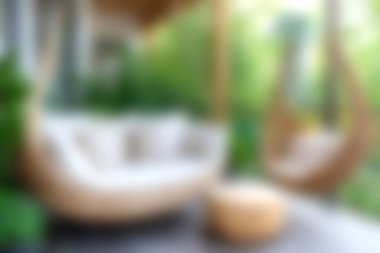 Hareketli yeşilliklerle çevrili sallanan sandalye ve pelüş yastıkların bulunduğu sakin bir açık hava salonu keşfedin. Rahatlama ve yaz toplantıları için ideal..