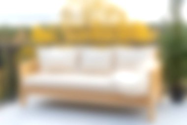 Yastıklarla bezenmiş şık ahşap bir kanepenin bulunduğu rahat bir açık hava oturma alanı, canlı sarı çiçeklerle çevrili, rahatlama ve keyif için mükemmel..