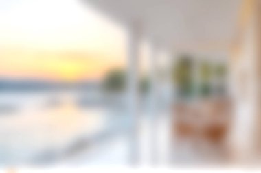 Günbatımında büyüleyici bir sahil manzarası yumuşak ışıklandırmalı modern mimariyi sergiliyor, rahatlama ve tatil için mükemmel sakin bir atmosfer yaratıyor..