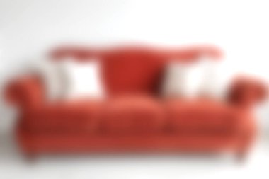 Yumuşak aksanlı yastıklarla süslenmiş şık kırmızı bir kanepe modern yaşam ortamında rahat ve davetkar bir atmosfer yaratıyor..