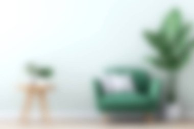 Kapalı bir bitki ve minimalist dekor eşliğinde, ışık dolu bir odaya yerleştirilmiş rahat yeşil bir koltuk, sakin ve davetkar bir atmosfer yaratıyor..