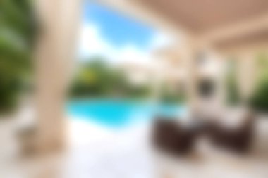 Işıl ışıl bir havuza bakan açık hava salonu, yemyeşil çerçeveli ve sakin bir ortamda yaz rahatlığı ve keyif için tasarlanmış..