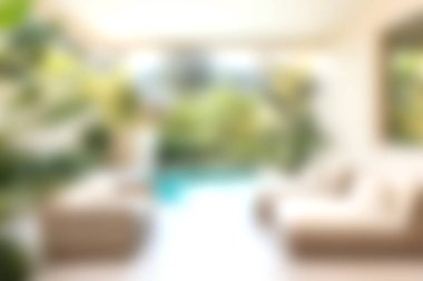 Bu görüntü, doğal ışıkla ıslanmış, iç mekan bitkileriyle dolu rahat bir oturma odası yakalıyor ve ferahlatıcı bir açık havuza bağlanan sakin bir atmosfer yaratıyor..