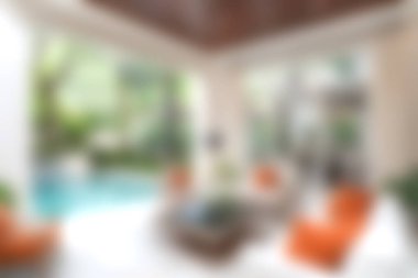 Canlı mobilyalarla dolu sakin bir tropikal oturma odası ve çağdaş ortamlarda rahatlamak ve rahatlamak için ideal ferahlatıcı bir havuz manzarası..