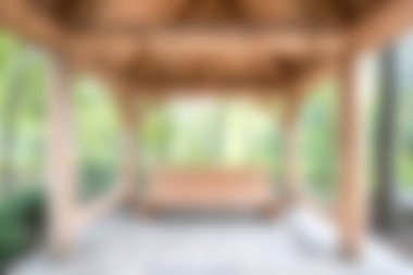 Tahtadan yapılmış sakin bir açık hava çardağı, yemyeşil bir arazide kurulmuş, doğanın kucaklamasında rahatlama ve sosyal toplanma için idealdir..