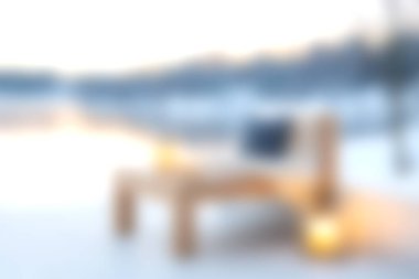 Sakin bir kış manzarasında, gün doğumunda huzurlu bir göl kenarında dizüstü bilgisayarı olan rahat bir sandalye, dinlenmek ve huzur verici bir ortamda ilham vermek için mükemmel..