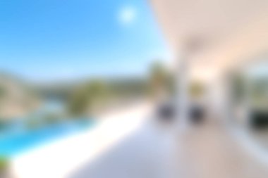 Bu resim, güneşli ve güneşli bir havuzu olan modern bir villayı çekiyor. Gün ışığında yıkanmış huzurlu bir açık hava manzarası sergiliyor. Rahatlamak ve rahatlamak için ideal..