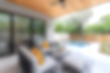 Bu resim rahat bir oturma odası, hareketli yastıklar ve yaz yaşamı için ideal rahatlatıcı bir ortam sunuyor..