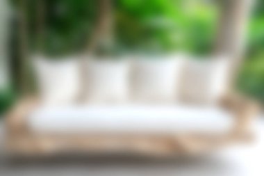 Beyaz yastıklarla bezenmiş rahat, ahşap bir kanepe, yemyeşil bir zemin üzerine kurulmuş, rahatlamanın ve sükunetin davetkar atmosferini arttıran..