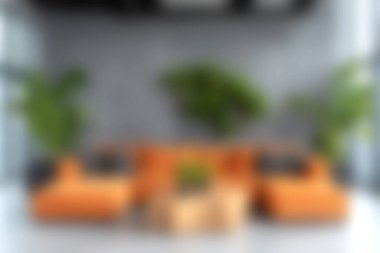 Turuncu bir kanepe ve yemyeşil bitkilerin bulunduğu modern bir oturma odası keşfedin, canlı ve davetkar bir atmosfer yaratın. Tasarım için mükemmel..