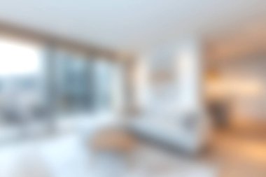 Bu resim, parlak doğal ışık, minimalist dekor ve geniş pencereli, sıcak ve davetkar bir atmosfer yaratan modern bir oturma odasını gösteriyor..