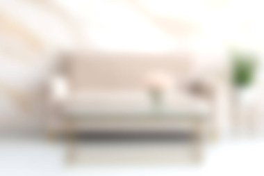 Bu resim, minimalist kanepesi ve zarif dekoru olan rahat ve modern bir oturma odasını gösteriyor. Yumuşak pastel renkler dingin ve davetkar bir atmosfer yaratır..