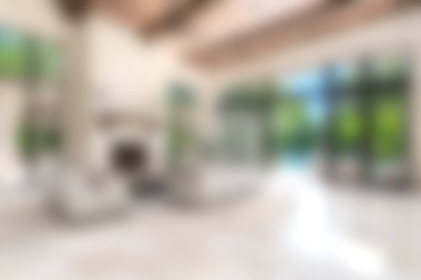 Modern mobilyaların, geniş pencerelerin ve huzurlu doğa manzarasının bulunduğu parlak ve davetkar bir oturma odası rahatlama için mükemmel bir ortam yaratıyor..