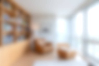 Bu resim, şık mobilyaları ve geniş pencereleri olan rahat, modern bir oturma odasını sergiliyor. Sıcak ve davetkar bir atmosfer yaratıyor. Rahatlamak için mükemmel..