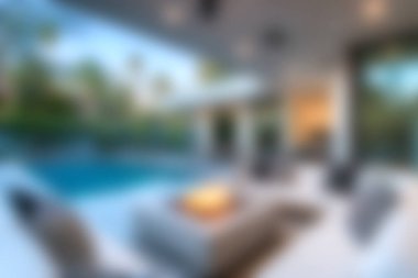 Bu görüntü, bir havuzu çevreleyen modern mobilyaların yer aldığı sakin bir açık hava yaşam alanını yakalıyor. Güneş ışığıyla aydınlanan alan, huzur ve keyfi huzurlu bir ortama davet eder..