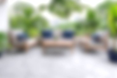 Bereketli yeşilliklerle çevrili modern mobilyaların bulunduğu, yaz toplantıları için huzurlu ve rahatlatıcı bir atmosfer sağlayan rahat bir açık hava alanı..