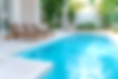 Berrak su ve yemyeşil şezlonglarla çevrili rahat bir yüzme havuzu, dinlenme ve rahatlama için ideal..