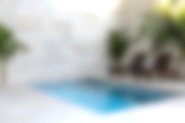 Sakin bir açık havuz alanı, modern tasarım elementleri ve yemyeşil ile çevrili sakin mavi bir su yüzeyi içerir ve mükemmel bir rahatlama noktası yaratır..