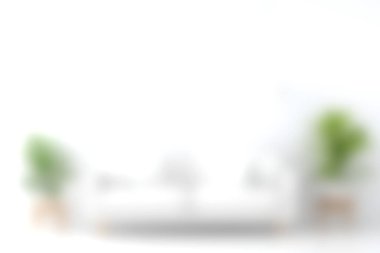 Parlak ve havadar modern bir oturma odasında yemyeşil bitkilerle çevrili beyaz bir kanepe rahatlama ve stil için mükemmel sakin ve davetkar bir atmosfer yaratıyor..