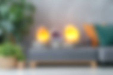 Bu görüntüde modern mobilyalar, çevre ışıkları ve dekoratif bitkilerin yer aldığı rahat bir oturma odası sergilenmekte, rahatlama ve rahatlama için mükemmel sıcak ve davetkar bir atmosfer yaratmaktadır..