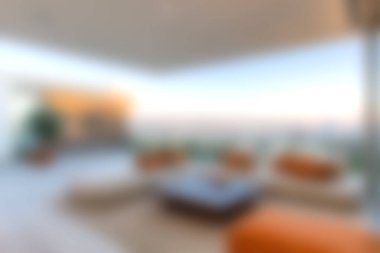 Modern bir oturma odası, şık mobilyalar ve geniş bir manzarası var. Yumuşak ışıklandırma rahatlama ve sosyal toplanma için mükemmel bir ortam yaratır..