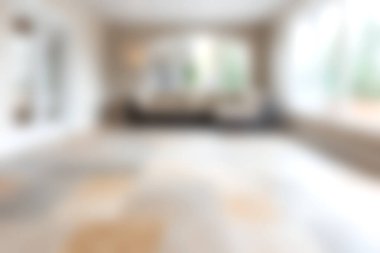 Bu resim, geniş pencereli modern bir oturma odasını gösteriyor. Parlak ve geniş alana geniş doğal ışık sağlıyor..