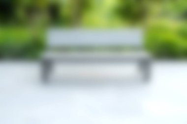 Yeşillik bir bahçe ortamındaki ahşap bir bankın yumuşak odaklı görüntüsü. Sahne sükuneti ve davetkar bir atmosferi taşır. Rahatlamak için mükemmeldir..