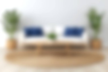 Mavi yastıklarla süslenmiş şık bir kanepenin olduğu rahat bir oturma odası sahnesi. Yeşil bitkiler tazelik katar, parlak ve davetkar bir atmosfer yaratır..