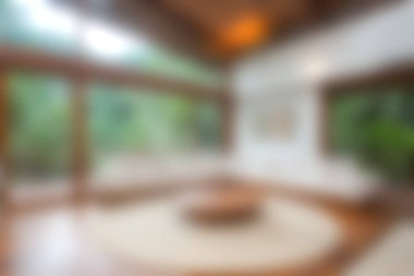 Doğal ışık ve yemyeşil alanları davet eden geniş pencereli modern ve minimalist bir oturma odası huzur verici ve rahatlatıcı bir ortam yaratıyor..