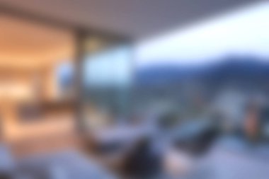 Günbatımında güzel bir panoramik manzarayı çerçeveleyen geniş pencereli çarpıcı modern bir oturma odası. Zarif dekor konforu ve tarzı karıştırır, sakin bir atmosfer yaratır..