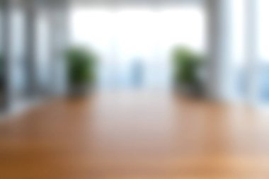 Bu yumuşak odaklı resimde modern bir ofis konferans masası sergileniyor. Taze yeşillik ve doğal ışık ile çevrili, iş kavramları için mükemmel..