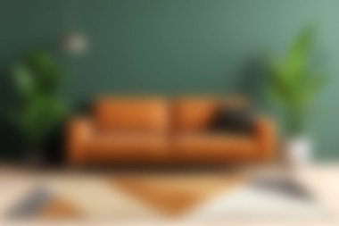 Yeşil bir duvara karşı modern bir deri kanepenin sergilendiği şık bir oturma odası. Kapalı alandaki bitkilerle tamamlanmış. Çağdaş iç tasarım estetiğini göstermek için mükemmel..