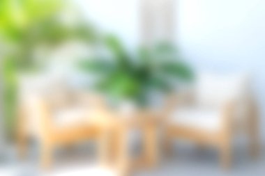 Rahat sandalyeler ve doğal elementlerle dolu sıcak ve davetkar bir oturma odası sahnesi. Bereketli yeşil bitkiler rahatlama ve sükunet için sakin atmosferi güçlendirir..