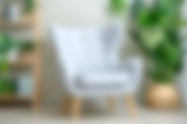 A stylish modern chair is the focal point in a bright living room, complemented by vibrant indoor plants, creating a serene and inviting atmosphere.