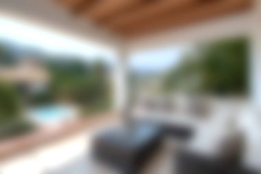 Discover a cozy outdoor living space featuring comfortable furniture and a stunning view of lush greenery and a tranquil pool, perfect for relaxation.