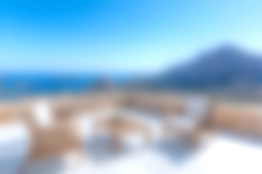 A serene outdoor lounge area featuring comfortable seating, overlooking a breathtaking ocean view and scenic mountain backdrop, perfect for relaxation.