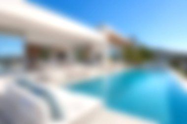 Stunning luxury villa with an inviting infinity pool under a clear blue sky. Ideal for relaxation and summer escapes, showcasing modern design and nature's beauty.