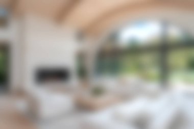 Doğal ışık, minimalist mobilyalar ve rahatlık için rahat bir atmosfere sahip geniş pencereli geniş bir oturma odası..