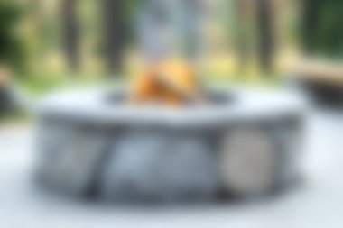 A serene outdoor setting featuring a cozy fire pit made of stone, perfect for gatherings with friends and family. Enjoy a relaxing atmosphere in nature.