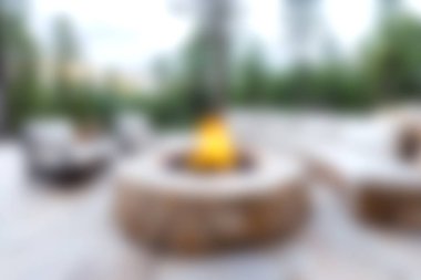 A serene outdoor scene featuring a cozy fire pit surrounded by comfortable seating, perfect for evening gatherings. Enjoy warmth and connection in nature.