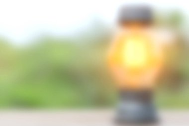 Yumuşak odaklı bir fener, bulanık doğal bir arka plan üzerine kurulmuş sıcak bir parıltı yayar, sakin ve davetkar bir atmosfer yaratır açık hava ayarları için mükemmel..