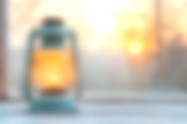 Büyüleyici bir klasik fener, bulanık bir günbatımı arka planına karşı sıcak bir parıltı yayar, sakin ve rahat bir ortam yaratır açık hava toplantıları veya huzurlu anlar için mükemmel..