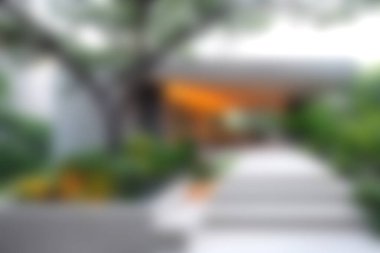 Yumuşak odak noktasında tasvir edilen yemyeşil ve modern mimari unsurlarla çevrili sakin bir yol, açık havada rahatlamaya ve barışa davet ediyor..